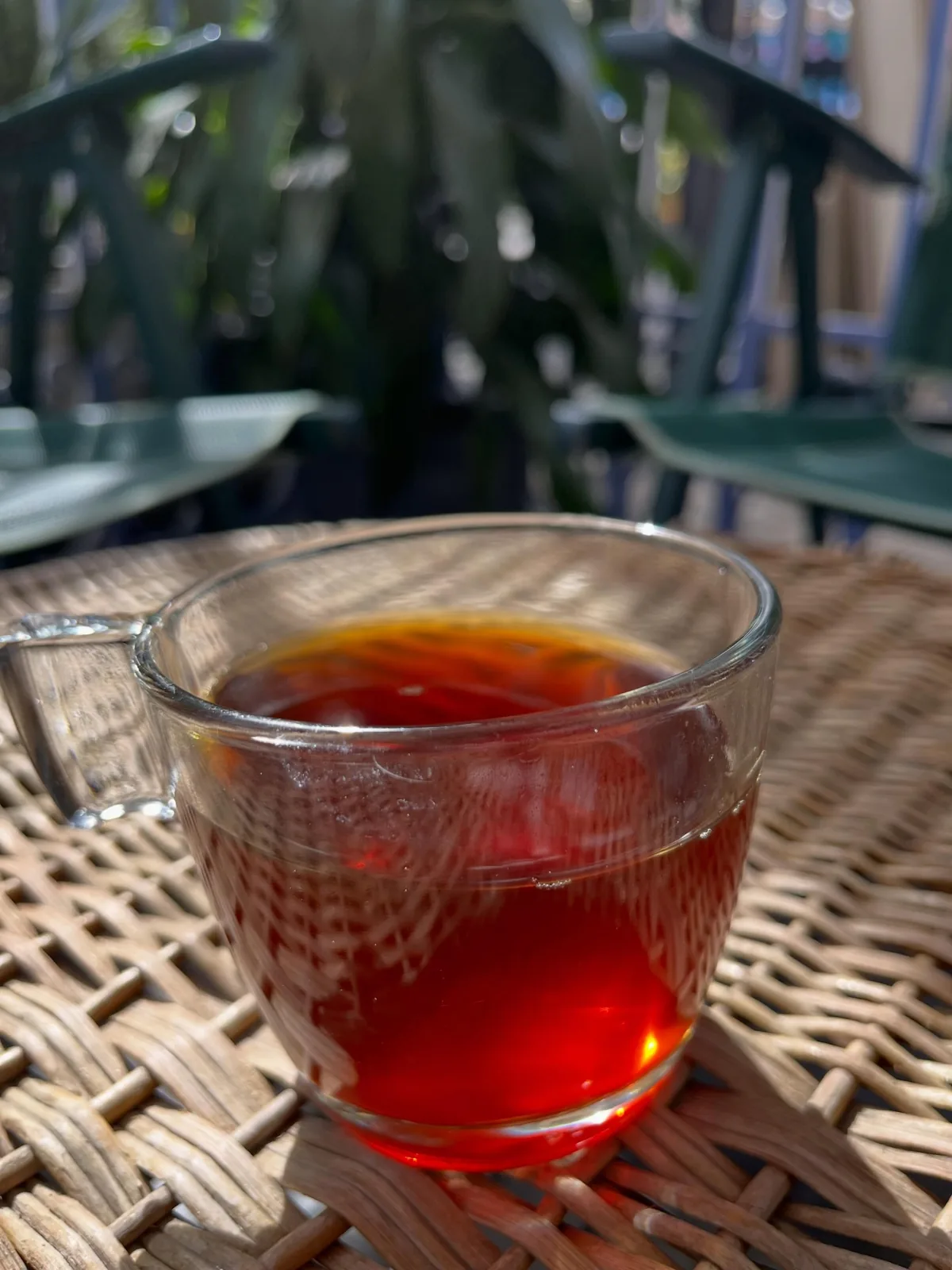 Taza de café filtrado sobre mesa de mimbre en la terraza del local